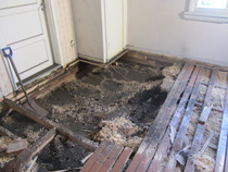 Lattiaremonttia.  Täytteenä käytetty hiili oli kostunut ja lahottanut lattian kannattajat